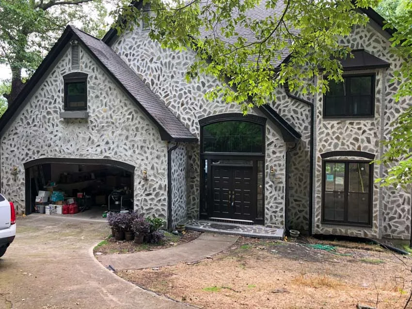 Stone home with new black-framed windows and door