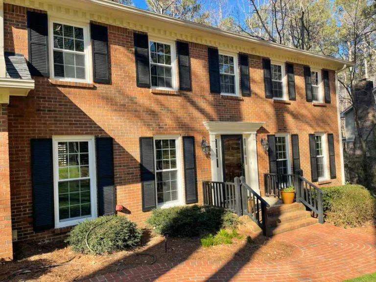 Brick colonial with new white windows and shutters