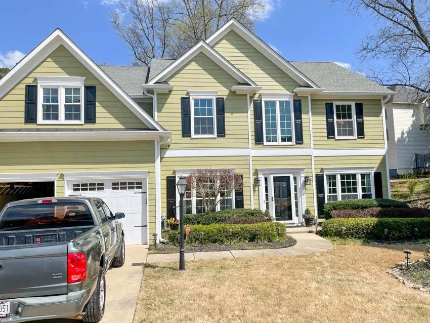 Two-story home with new white windows and black shutters